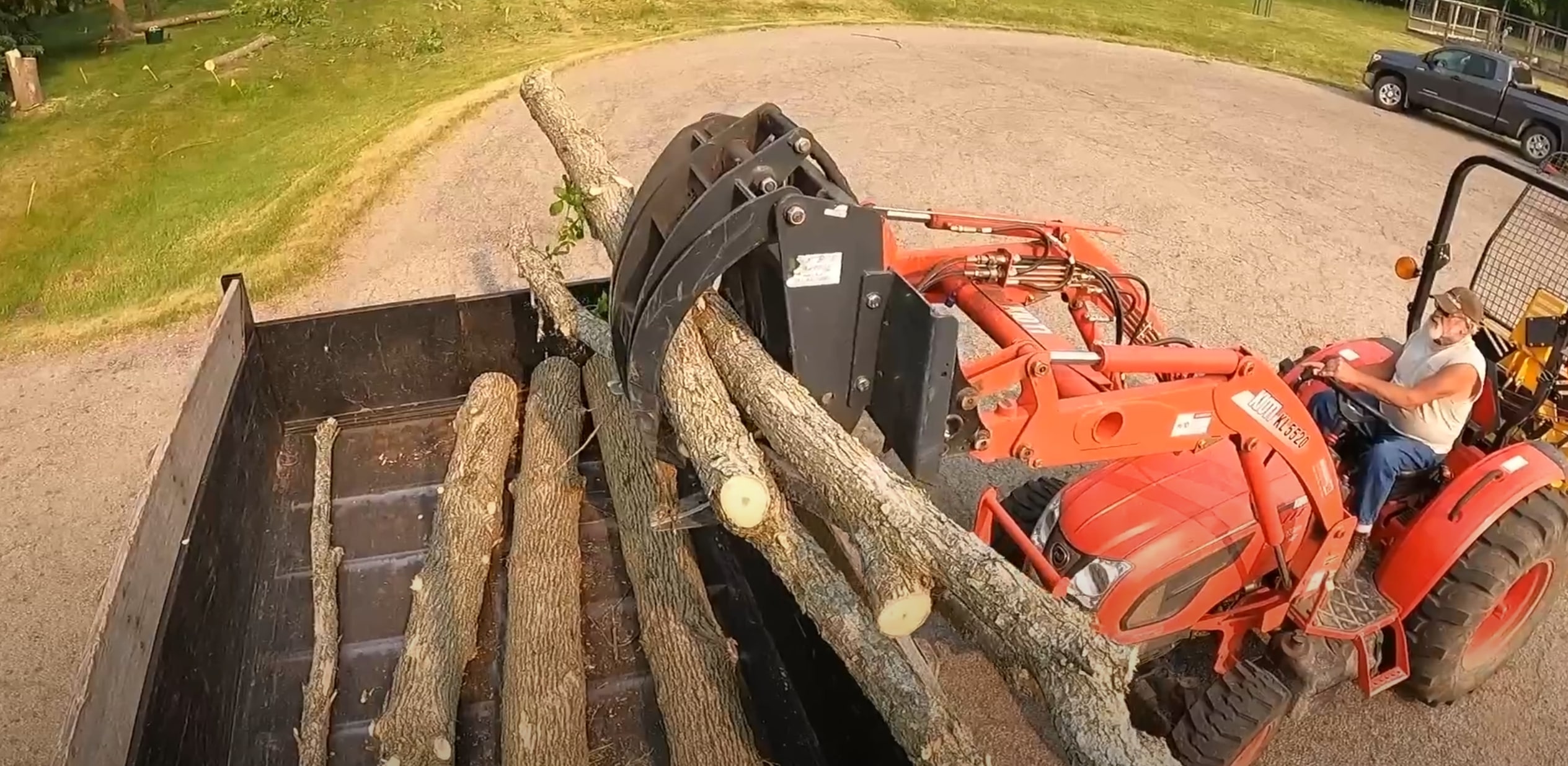 Tree removal service with professional tractor equipment hauling cut tree logs